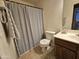 Cozy bathroom featuring a single sink vanity, tile floors and a shower with a patterned curtain at 592 E 9Th Ave, Apache Junction, AZ 85119