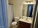Cozy bathroom featuring a single sink vanity, tile floors and a shower with a patterned curtain at 592 E 9Th Ave, Apache Junction, AZ 85119