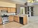 Kitchen with stainless steel oven, black dishwasher, tile flooring and pass through to the living area at 592 E 9Th Ave, Apache Junction, AZ 85119