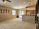 Open-concept living room showcasing neutral carpet and access to the patio and kitchen at 592 E 9Th Ave, Apache Junction, AZ 85119