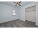 Bright bedroom features gray wood-look flooring, ceiling fan, and closet at 6025 W Marconi Ave, Glendale, AZ 85306