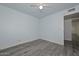 Cozy bedroom with wood-look floors, ceiling fan, and access to additional rooms at 6025 W Marconi Ave, Glendale, AZ 85306