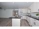 Open concept kitchen with island, white cabinets, granite countertops, and stainless steel appliances at 6025 W Marconi Ave, Glendale, AZ 85306