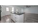 Kitchen island with black granite countertop and white cabinets, connecting kitchen to living space at 6025 W Marconi Ave, Glendale, AZ 85306