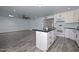 Open concept layout with kitchen island, ceiling fan, recessed lighting, and wood-look flooring at 6025 W Marconi Ave, Glendale, AZ 85306