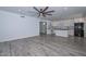 Open-concept living room and kitchen with gray floors, white cabinets, and modern appliances at 6025 W Marconi Ave, Glendale, AZ 85306