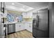 Updated kitchen features stainless steel appliances, white cabinets, and modern fixtures at 6201 W Acoma Dr, Glendale, AZ 85306