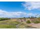 Scenic view of a park featuring green spaces, walking paths, trees, and blue skies with clouds at 6201 W Acoma Dr, Glendale, AZ 85306