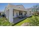 Relax on the covered back patio with striped furniture, ceiling fan, and low-maintenance artificial grass at 6334 E Viewmont Dr # 29, Mesa, AZ 85215