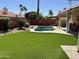 Inviting backyard featuring a beautiful pool, lush landscaping, and artificial turf for easy maintenance and relaxation at 657 N Marble St, Gilbert, AZ 85234