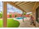 Relaxing covered patio with a view of the pool and landscaped backyard at 657 N Marble St, Gilbert, AZ 85234