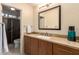 Bathroom featuring a glass-enclosed shower and single sink vanity with marble countertop at 7380 E Turquoise Ave, Scottsdale, AZ 85258