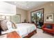 Well-lit bedroom showcasing a comfortable bed, sitting area, and access to the outdoors at 7380 E Turquoise Ave, Scottsdale, AZ 85258