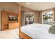 Spacious bedroom with a four-poster bed, media center, and access to the patio at 7380 E Turquoise Ave, Scottsdale, AZ 85258