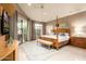 Bright bedroom with a four-poster bed, bench, and large windows overlooking the backyard at 7380 E Turquoise Ave, Scottsdale, AZ 85258