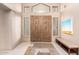 Elegant entryway with a double door, accent rug, neutral tones and bench seating at 7380 E Turquoise Ave, Scottsdale, AZ 85258