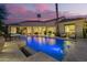 Luxurious backyard pool illuminated against a vibrant dusk sky, offering a serene oasis at 7380 E Turquoise Ave, Scottsdale, AZ 85258
