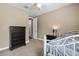 Calm bedroom features dresser, nightstand, white metal bed, and ceiling fan at 7537 E Plata Ave, Mesa, AZ 85212