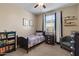 Cozy bedroom with a single bed, dark blue accents, and a bright window at 7537 E Plata Ave, Mesa, AZ 85212