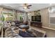 Spacious living room featuring a large brown leather couch, ceiling fan, and natural light at 7537 E Plata Ave, Mesa, AZ 85212