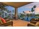 A relaxing outdoor space features comfortable seating with a serene view of the water feature and palm trees at sunset at 7700 E Gainey Ranch Rd # 222, Scottsdale, AZ 85258