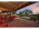 Covered patio with outdoor dining area, built-in grill, and lush garden view at 8003 E Sands Dr, Scottsdale, AZ 85255