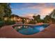 Backyard pool featuring a red brick surround, tropical landscaping and a covered patio at 8003 E Sands Dr, Scottsdale, AZ 85255
