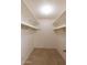 Spacious walk-in closet featuring neutral walls, tile flooring, and shelving for efficient storage solutions at 8666 E Fillmore St, Scottsdale, AZ 85257