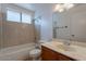 Bathroom featuring a single sink vanity and a tiled shower-tub, offering essential amenities at 10647 N 63Rd Dr, Glendale, AZ 85304