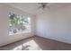 Bright bedroom featuring a ceiling fan and large window, offering ample light and ventilation at 10647 N 63Rd Dr, Glendale, AZ 85304