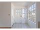 Bright foyer featuring tile flooring, decorative front door, and a large window at 10647 N 63Rd Dr, Glendale, AZ 85304