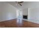 Bright living room featuring hardwood flooring, a ceiling fan and a fireplace at 10647 N 63Rd Dr, Glendale, AZ 85304