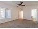 Bright main bedroom featuring a ceiling fan, window and neutral carpeted flooring at 10647 N 63Rd Dr, Glendale, AZ 85304