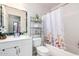 Bathroom featuring under sink storage, a decorative mirror, and a shower and tub combo at 11226 W Glenrosa Ave, Phoenix, AZ 85037