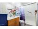 Bathroom with a modern shower, wood cabinets, and a decorative floral arrangement at 11226 W Glenrosa Ave, Phoenix, AZ 85037