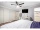 A bright bedroom featuring a ceiling fan, wood floors, and a clean, relaxing aesthetic at 11226 W Glenrosa Ave, Phoenix, AZ 85037