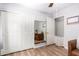 Bedroom featuring wood floors, sliding closet doors, and a large mirror at 11226 W Glenrosa Ave, Phoenix, AZ 85037