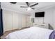 Bedroom featuring a ceiling fan, wood floors, and a set of sliding closet doors at 11226 W Glenrosa Ave, Phoenix, AZ 85037