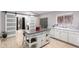 Bright kitchen with central island, barn doors, white cabinets, and white appliances at 11226 W Glenrosa Ave, Phoenix, AZ 85037