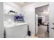 Bright laundry room featuring white washer and dryer with shelving and open door at 11226 W Glenrosa Ave, Phoenix, AZ 85037