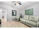 Bright living room features a ceiling fan, neutral walls, tile flooring, and a comfortable sofa at 11226 W Glenrosa Ave, Phoenix, AZ 85037