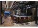 An interior bar with red leather stools, hardwood floors, a stone accent wall, and desert landscape view at 12326 E Black Rock Rd, Scottsdale, AZ 85255