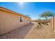 Side view of home showcasing desert landscaping, covered patio, and views of the spacious backyard at 1268 S 238Th Ln, Buckeye, AZ 85326