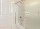 View of tub/shower combo with frosted glass, shelving and white tile at 1268 S 238Th Ln, Buckeye, AZ 85326