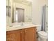 This bathroom offers a wood vanity, a white toilet, and a shower with blue curtain at 1268 S 238Th Ln, Buckeye, AZ 85326