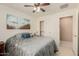 A bright bedroom features a ceiling fan and a comfortable queen-sized bed with decorative pillows and stylish comforter at 1268 S 238Th Ln, Buckeye, AZ 85326