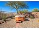 Hot tub in landscaped backyard offers a relaxing retreat with a wooden surround and privacy fencing at 1268 S 238Th Ln, Buckeye, AZ 85326