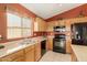 Modern kitchen with black appliances, light wood cabinets and tile flooring at 1268 S 238Th Ln, Buckeye, AZ 85326