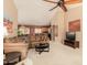 Open-concept living room with neutral carpeting, ceiling fan, and view into the kitchen and dining area at 1268 S 238Th Ln, Buckeye, AZ 85326