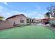 A home's sprawling backyard, featuring a putting green, pool area, and lush desert landscaping at 1708 W Gambit Trl, Phoenix, AZ 85085